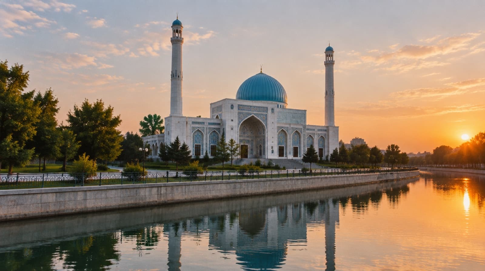 The white Minor Mosque with its blue dome beside the canal in Tashkent at sunset